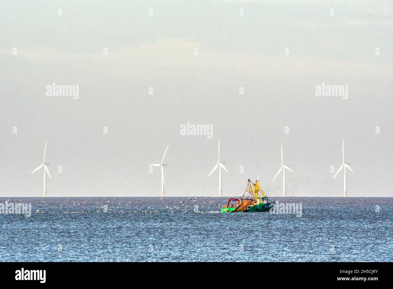 Trawler-dredger fishing boat Jolene of King's Lynn fishing in front of the Race Bank offshore wind farm.  Off the North Norfolk coast at Brancaster. Stock Photo