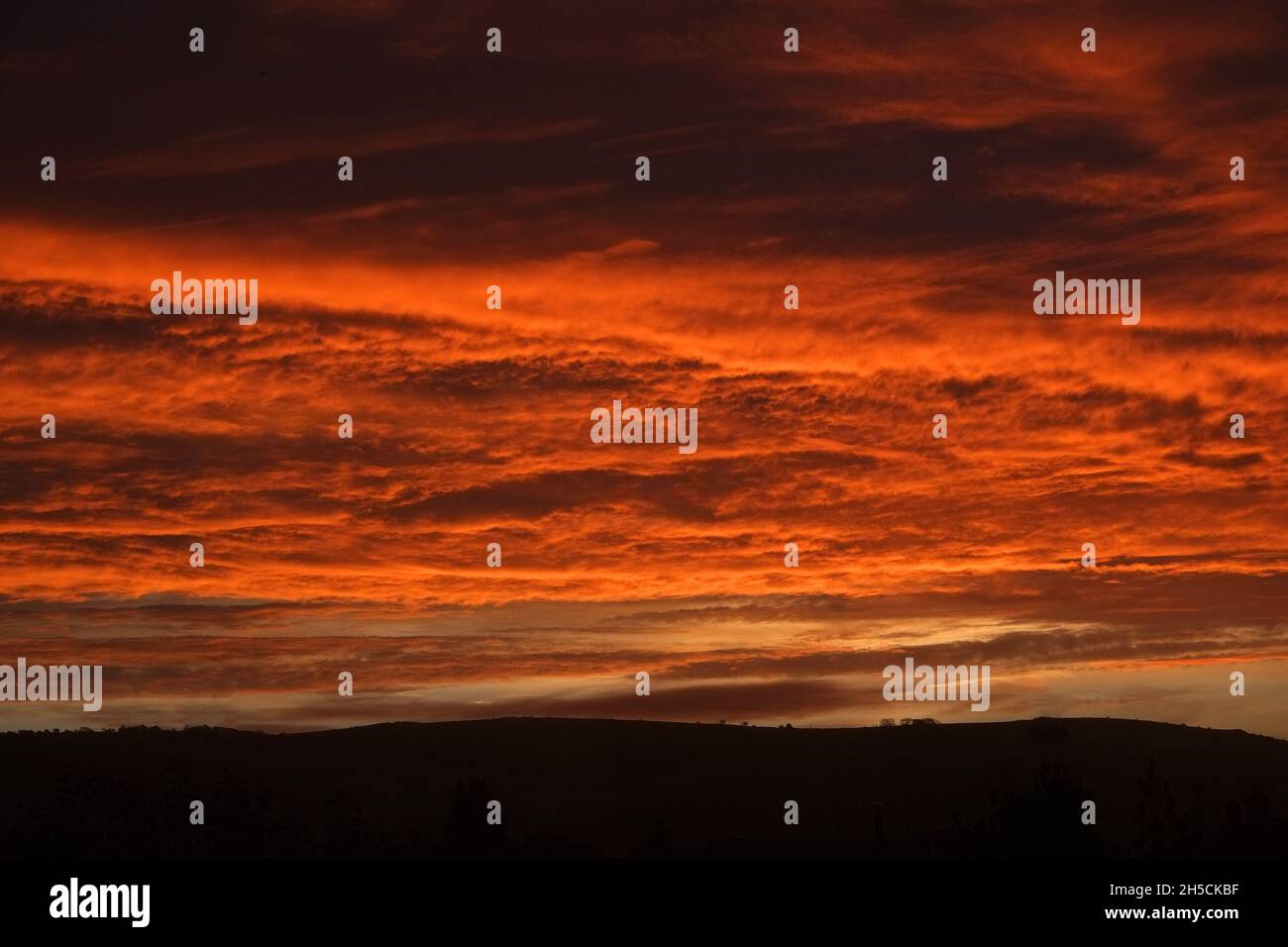 November 2021 - Heavy clouds at an orange dawn, in rural Somerset, England. Stock Photo