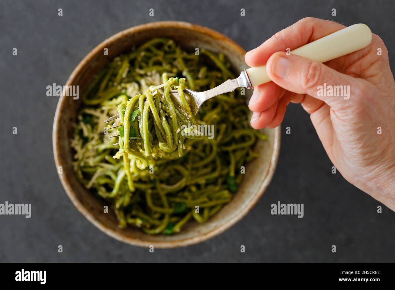 Eating a bowl of spaguetti. Hand with a fork having the meal. Stock Photo