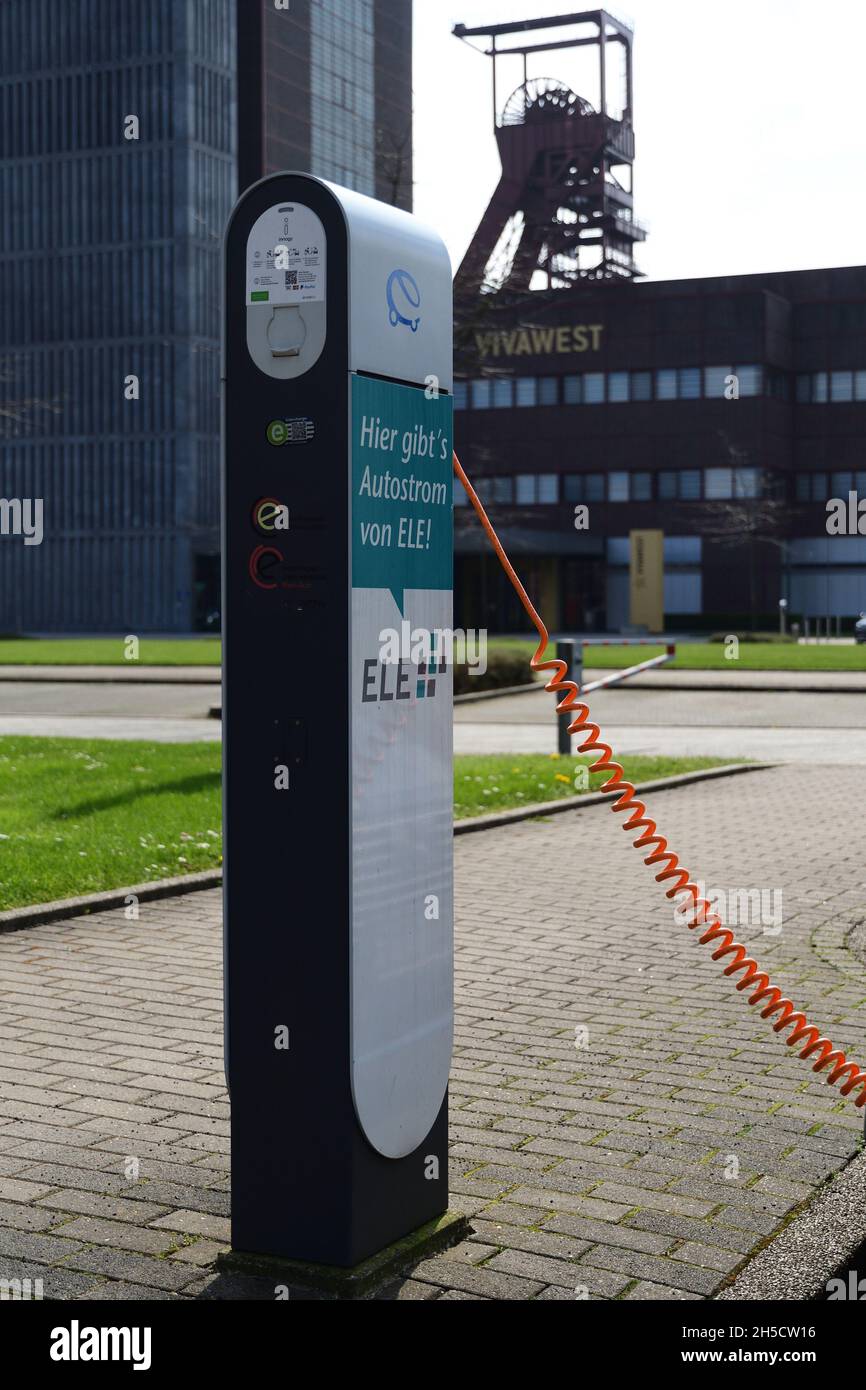 Electric charging station with winding tower in the background, Germany, North Rhine-Westphalia, Ruhr Area, Gelsenkirchen Stock Photo