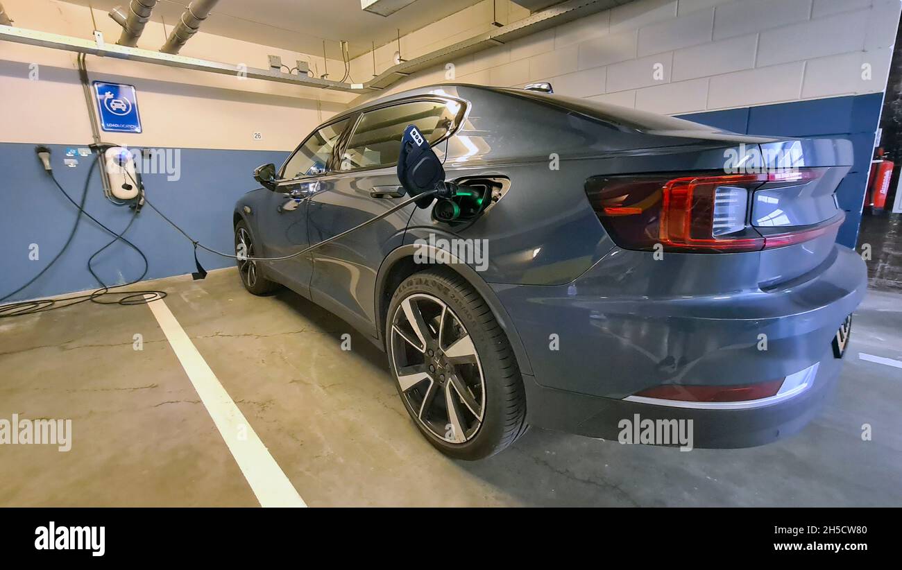 Electric car is charged in an underground car park Stock Photo