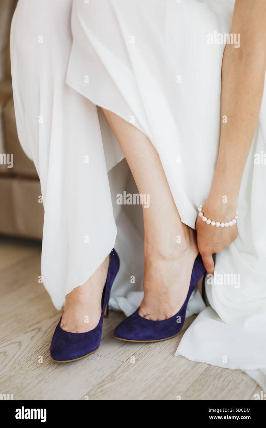 her arm wears blue high-heeled shoes 