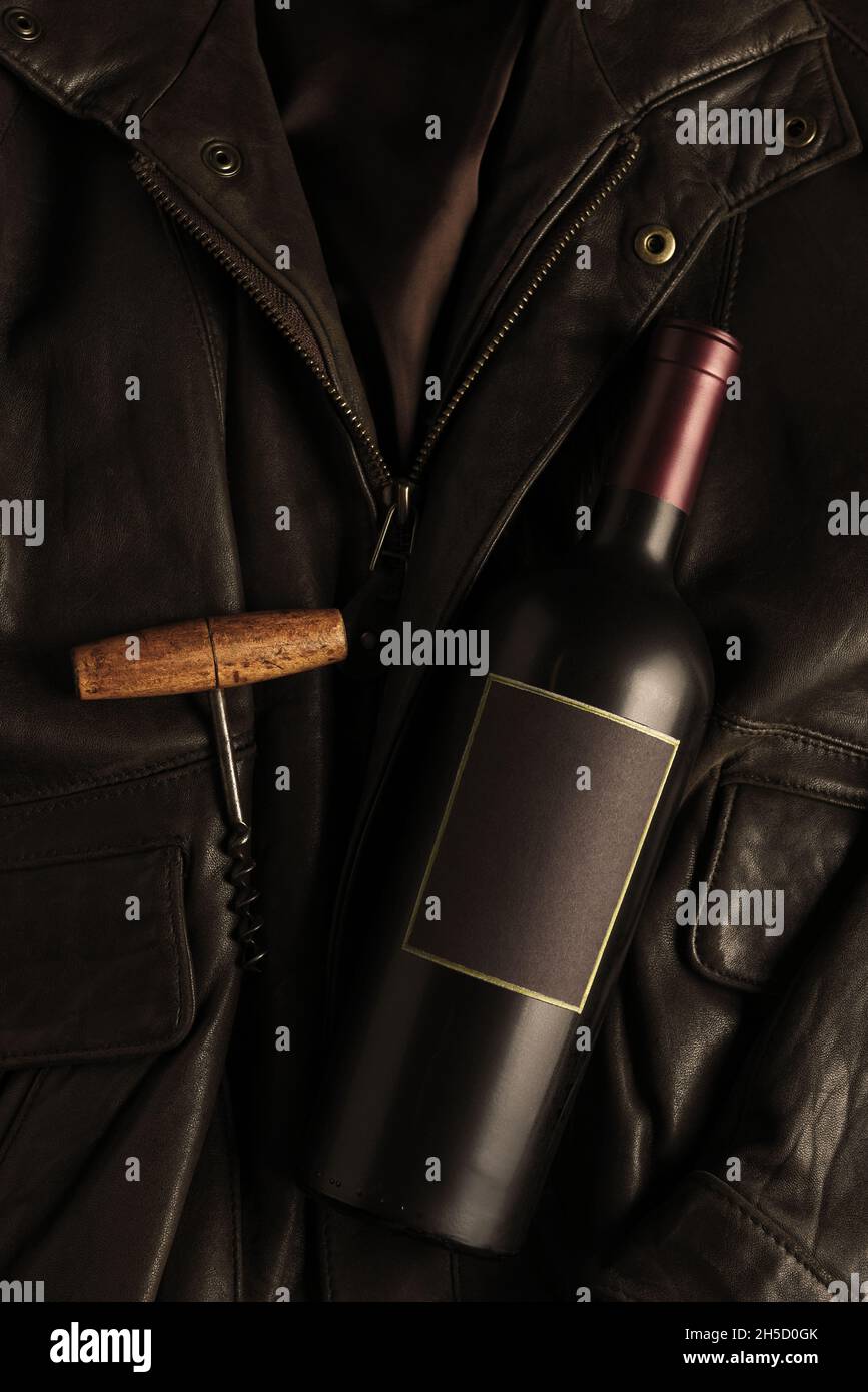 Wine bottle and corkscrew on a leather bomber jacket. Flat lay with