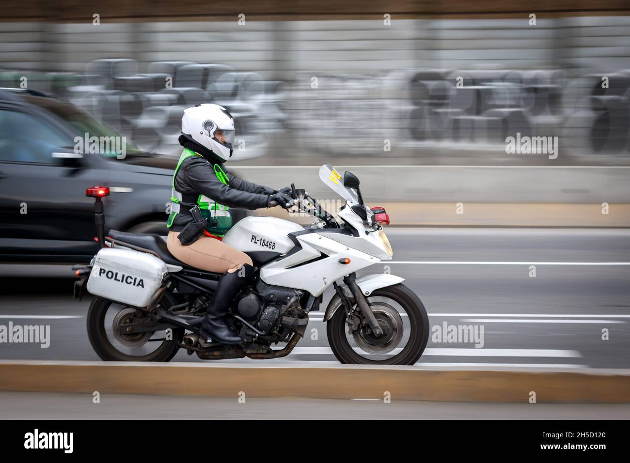 Police woman riding a motorcycle on a street Stock Photo