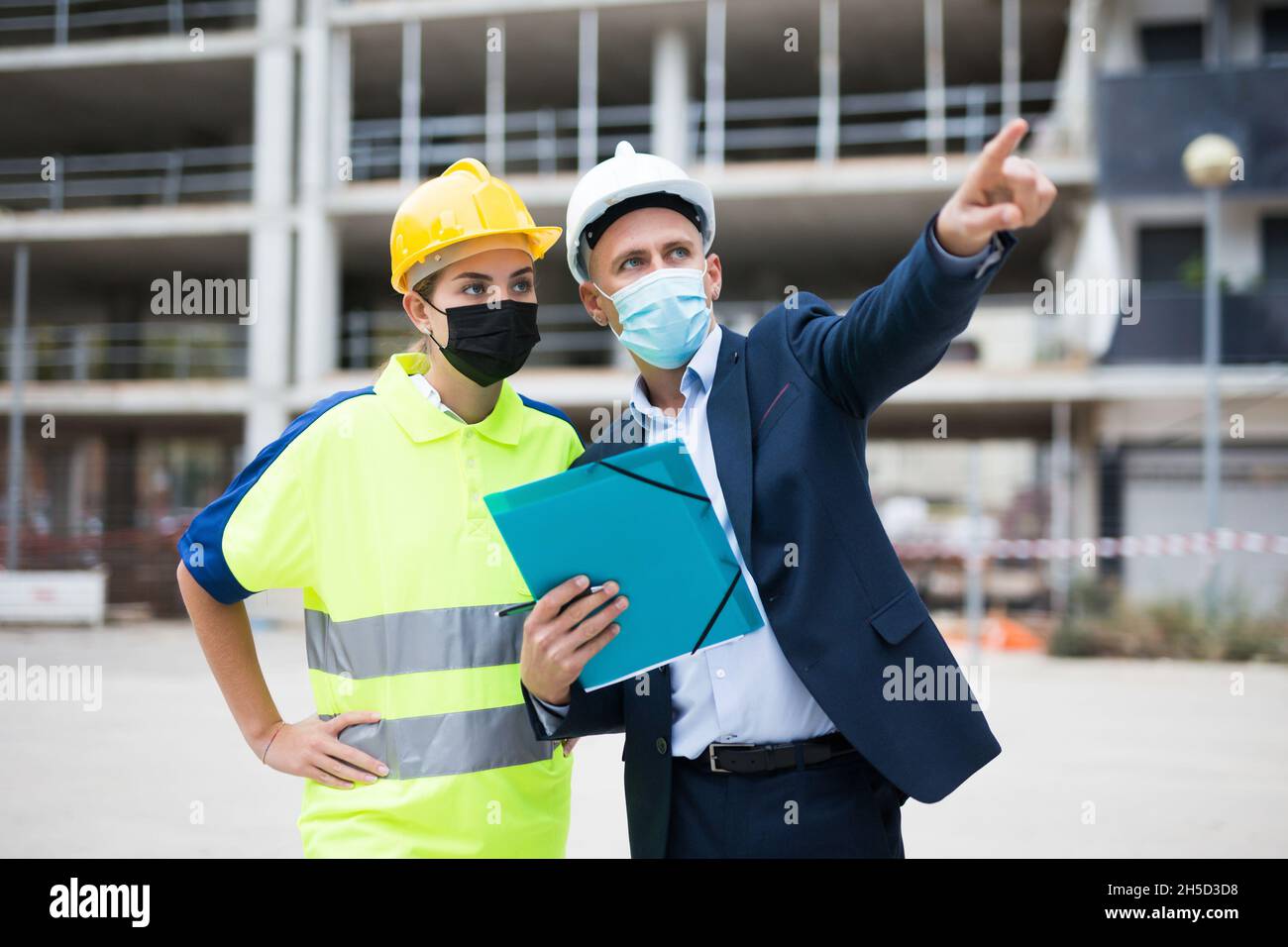 Civil engineers in masks checking work process Stock Photo