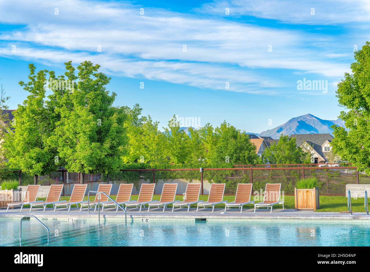 Lounge chairs on a public pool with wired fence at Daybreak, Utah Stock Photo