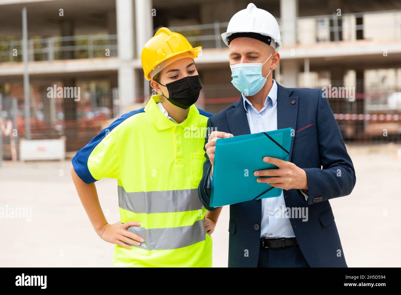 Civil engineers in masks checking work process Stock Photo