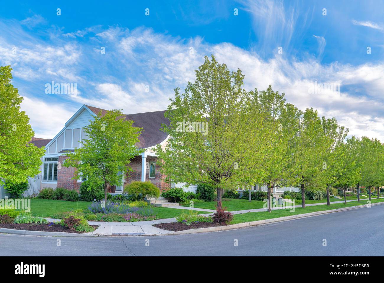 Corner house with bricks siding, flowers and trees on the lawn at Daybreak, Utah Stock Photo Alamy