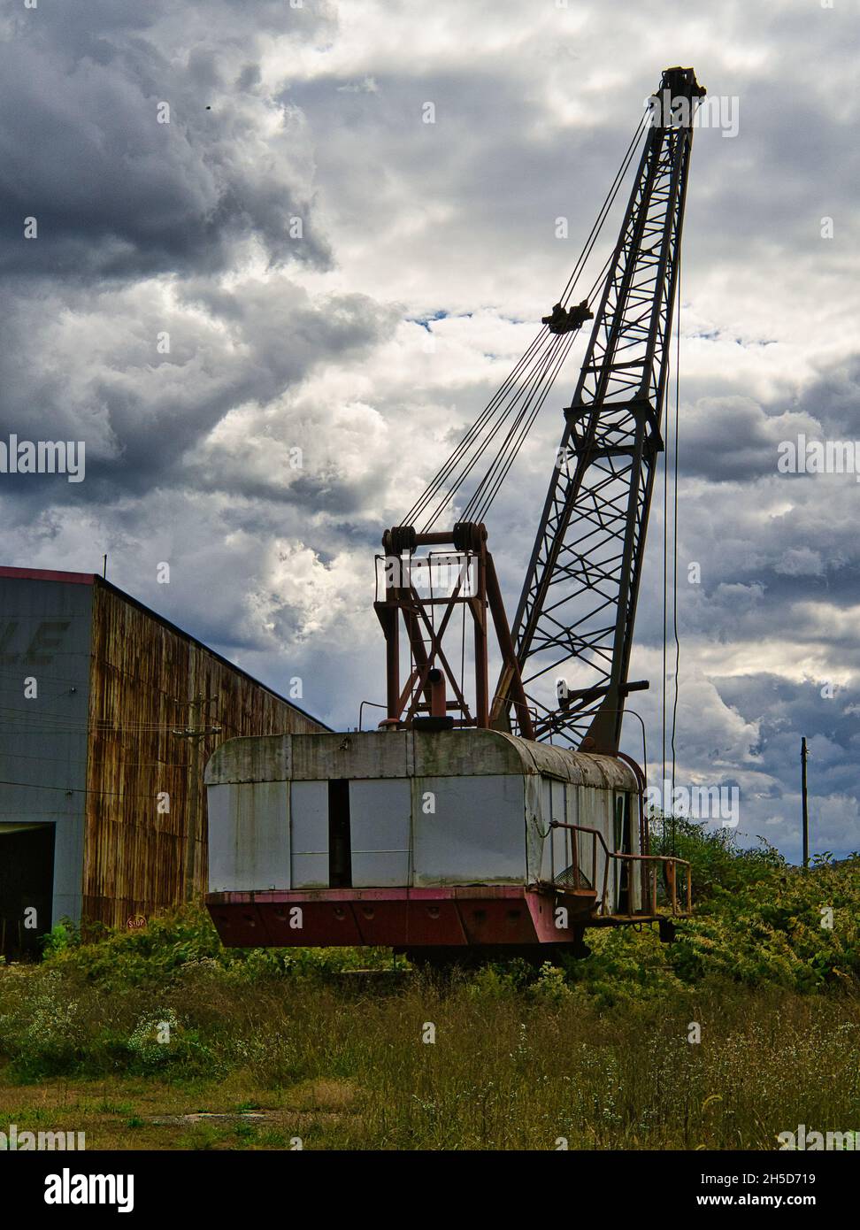 An Old mobile crawler crane with a stormy sky background. Stock Photo