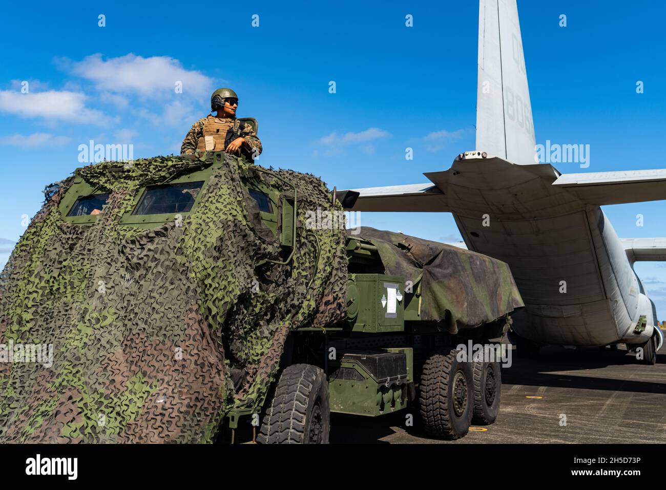 A U.S. Marine with 3d Battalion, 12th Marines, 3d Marine Division, moves to a hide position during a High Mobility Artillery Rocket System rapid aerial insertion mission at Iwo To, Japan, Nov. 1, 2021. Upon landing, Marines swiftly moved to a concealed position and prepared to engage simulated targets. The training demonstrated 3d Marine Division’s ability to quickly deploy long range precision fires capabilities to key maritime terrain across the Indo-Pacific region. (U.S. Marine Corps photo by Lance Cpl. Ujian Gosun) Stock Photo