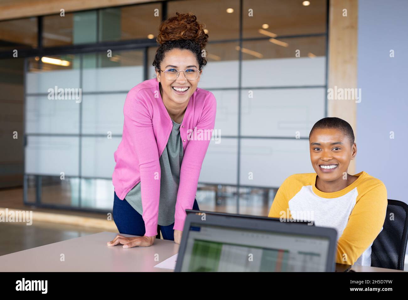 Businesswomen smiling at office desk hi-res stock photography and ...
