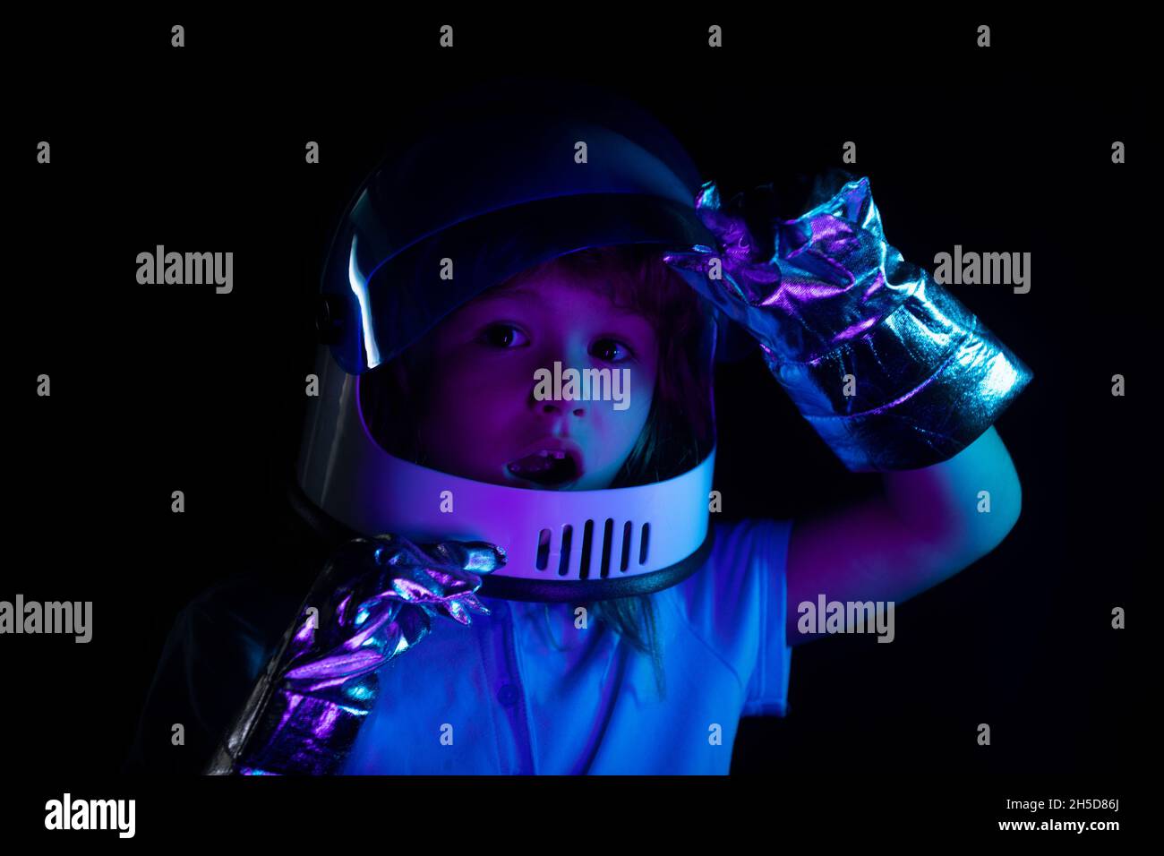 Child boy imagines himself to be an astronaut in an space helmet. Close up excited kids face. Stock Photo