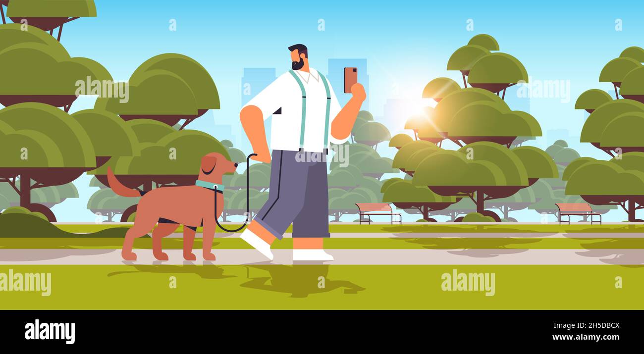 young man walking with dog in urban park male owner and cute domestic ...