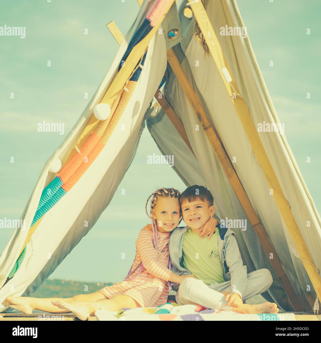 Sisters spending time in a tent on camping. Children using tablet playing games  online during summer vacation - a Royalty Free Stock Photo from Photocase