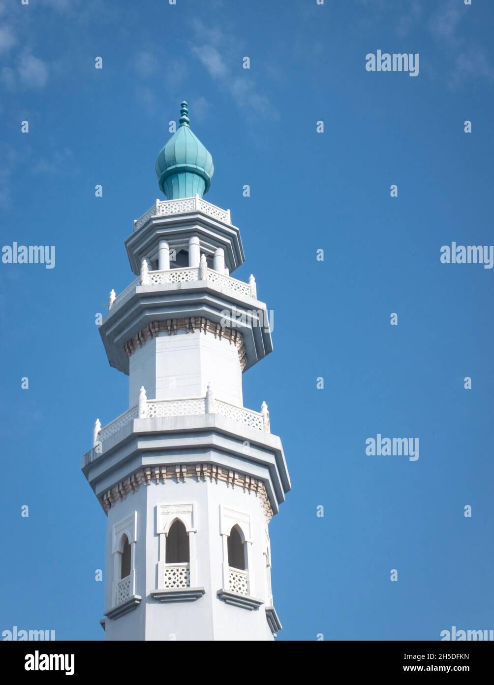 Mosque minaret against blue sky. Copy space. Stock Photo