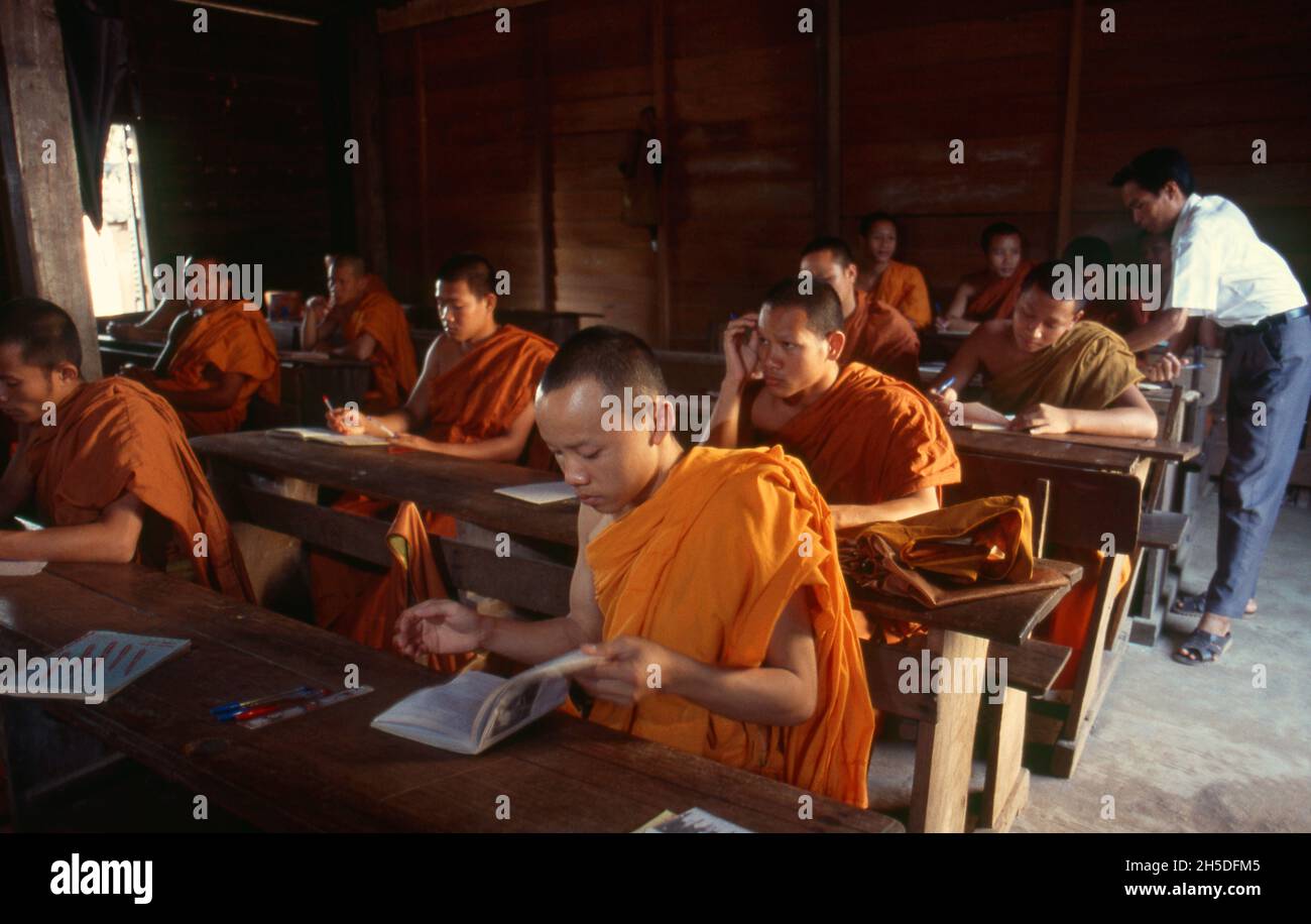 Laos: Young Buddhist monks studying at the Song Upper Secondary School, Wat Luang, Pakse, Champasak Province, southern Laos. Wat Luang is one of Pakse's largest and most ornate temples, featuring some unusually inventive yet pleasing murals. A beautiful wooden building on the banks of the river houses the Song Upper Secondary School for monks. Stock Photo