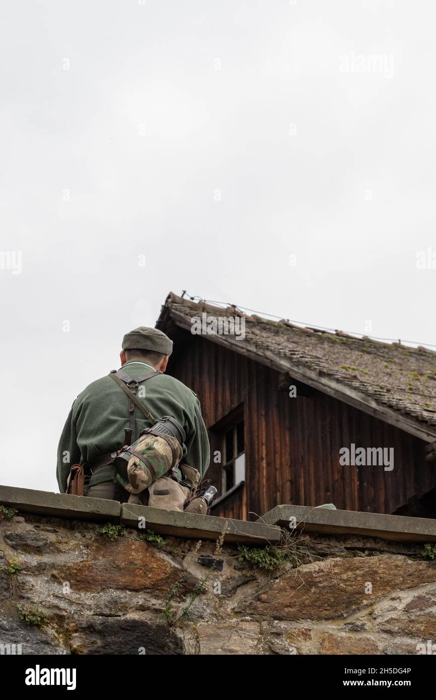 Soldier sitting on the wall, view from behind. World War II. Stock Photo