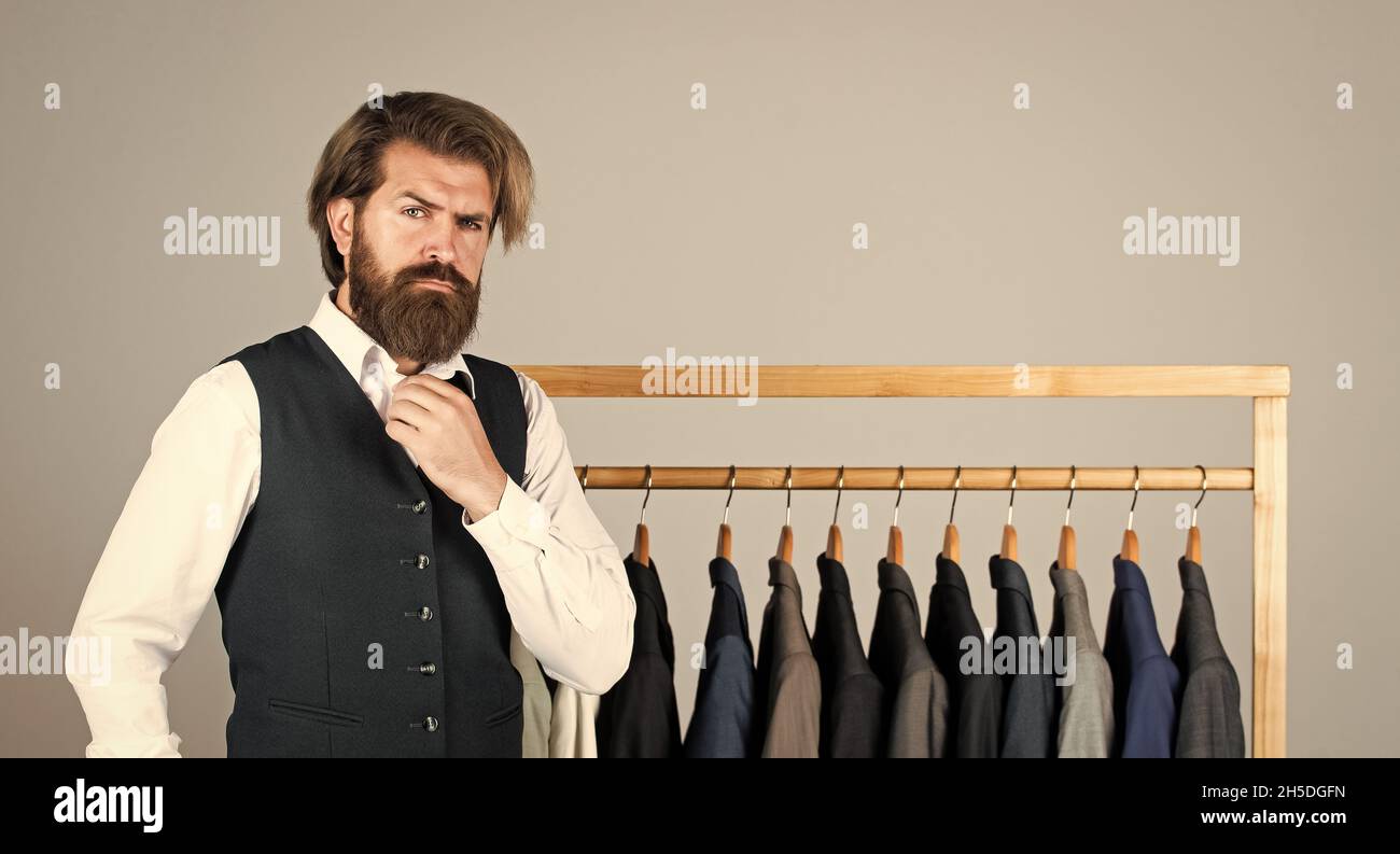 Man picking suit from personal wardrobe, fashion clothes concept Stock Photo