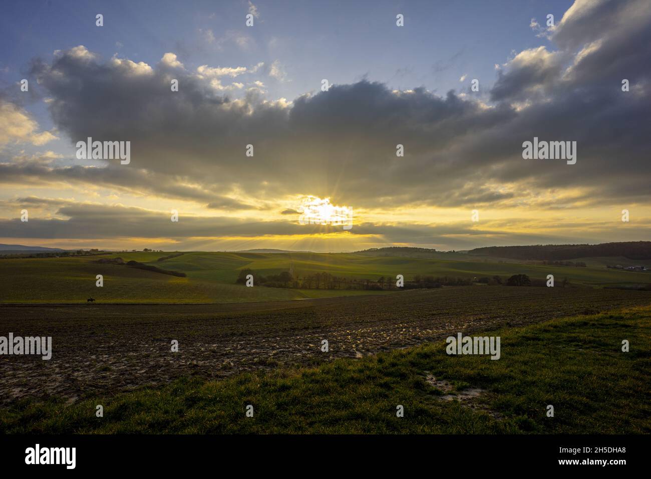 Scenic view of the sunrise through clouds over an agricultural field ...