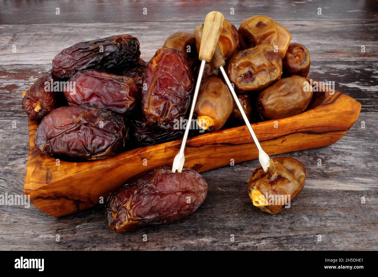 Group of ripe soft and sticky medjool and zamli dates in an olive wood