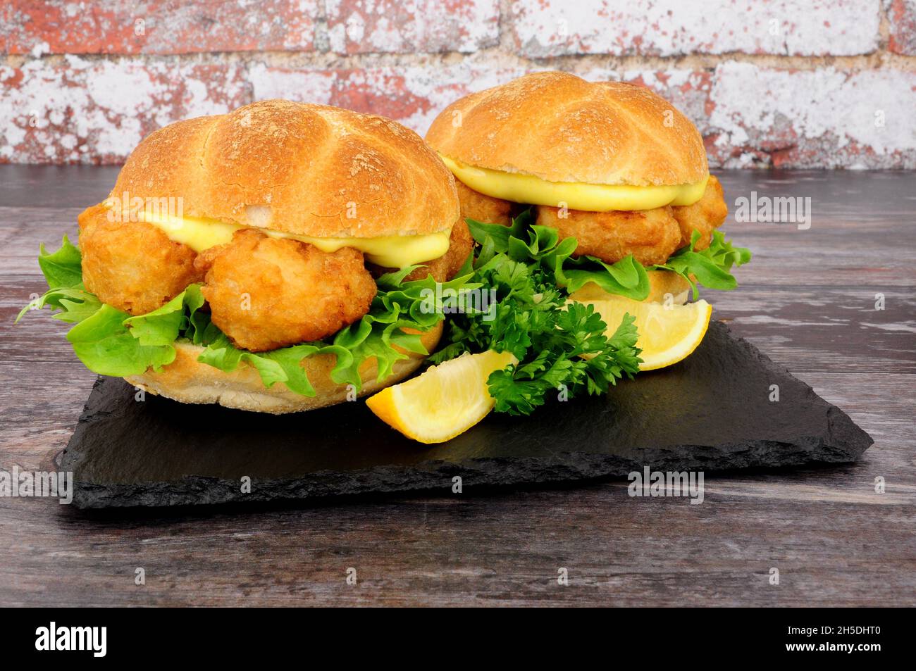 Battered cod fish nugget sandwiches with mayonnaise and lettuce in crusty bread rolls Stock
