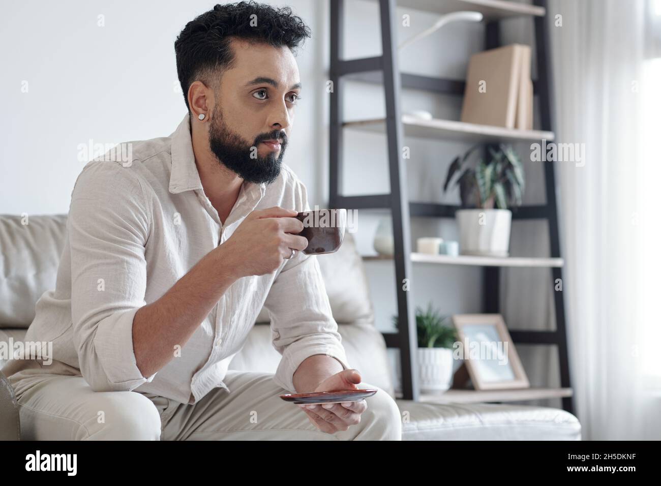 Male hipster using smartphone in concrete basement · Free Stock Photo
