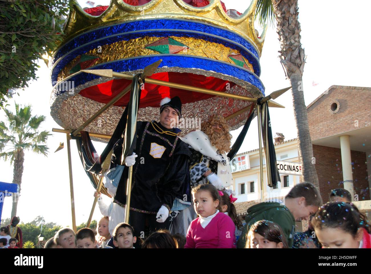 Three Kings Parade with Gaspar standing in his carriage and children sitting on the float, La Cala de Mijas, Spain Stock Photo