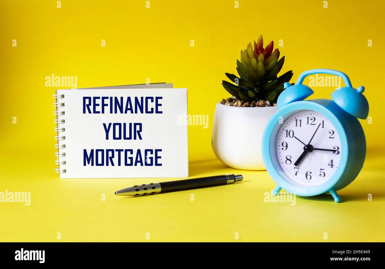 Refinance your mortgage, text on notepad and yellow background. Business concept Stock Photo