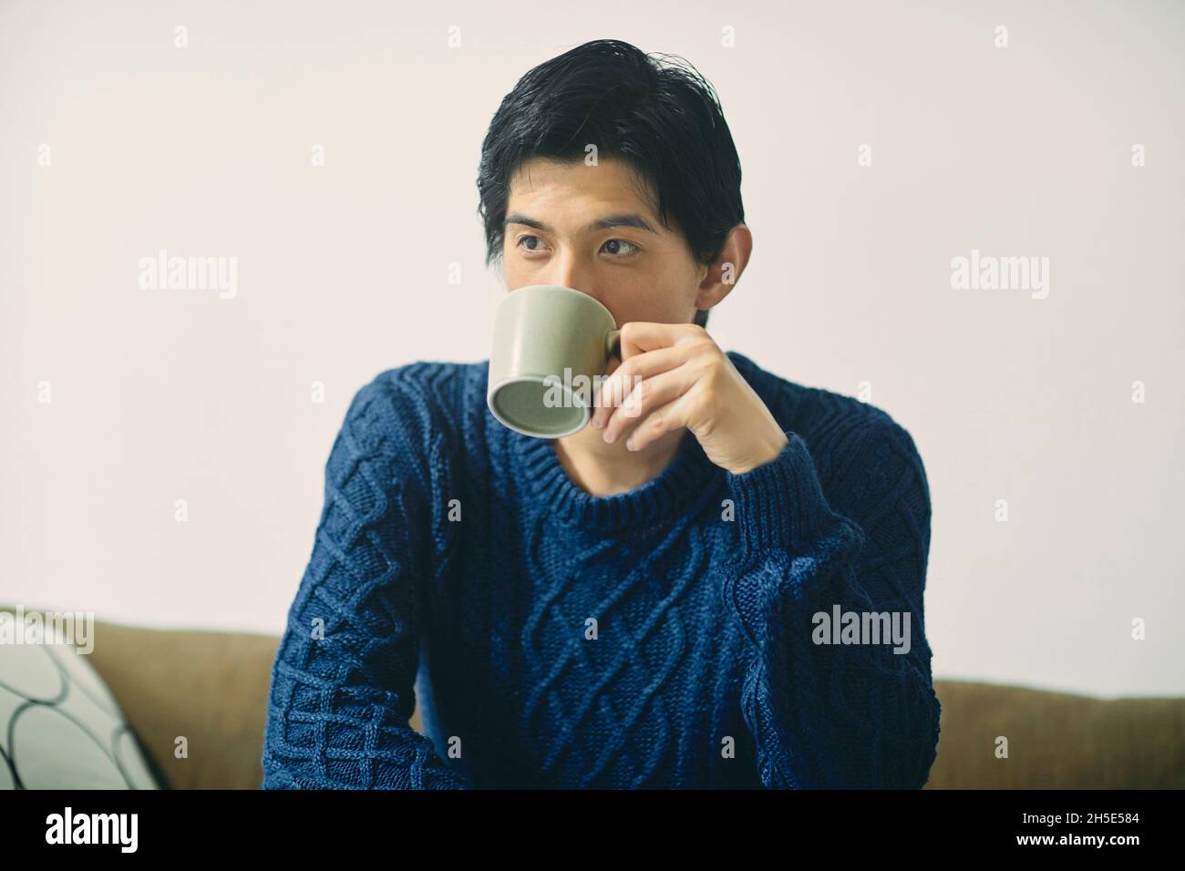 Japanese man relaxing on the sofa Stock Photo - Alamy