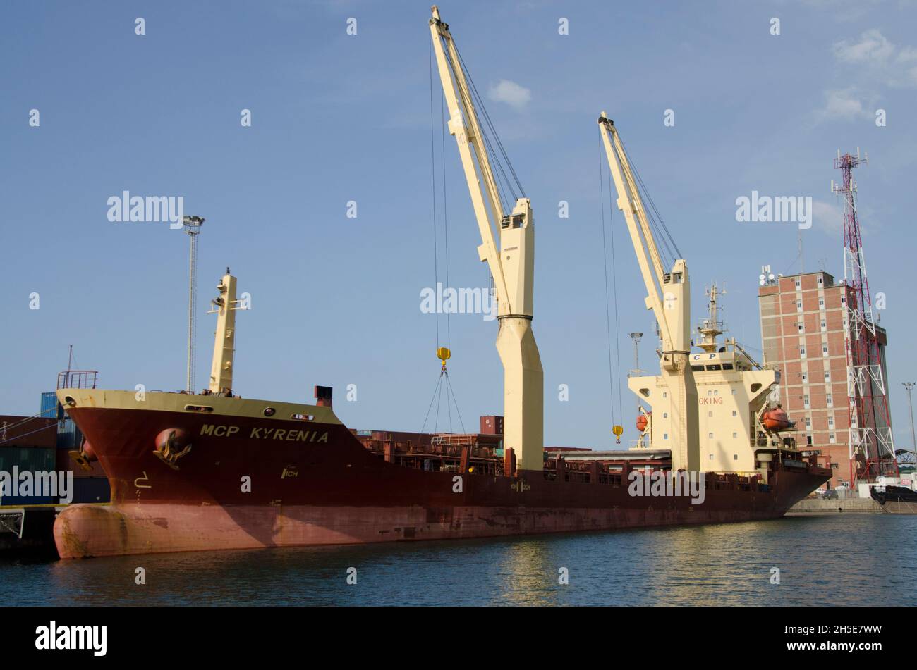 Moored container ship being unloaded with the use of two cranes Stock Photo