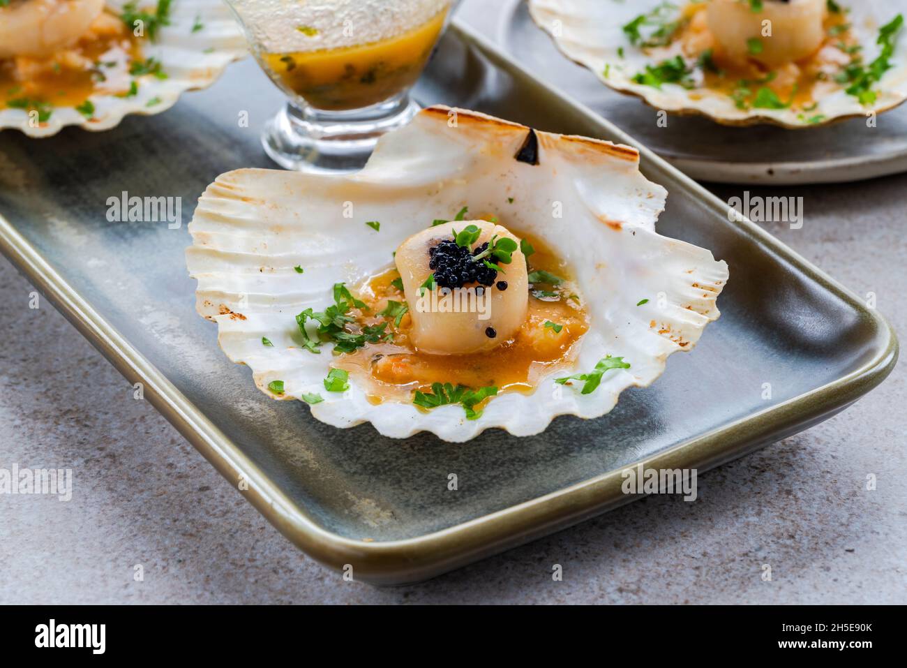 Canapes with scallops, caviar and lime and butter sauce in shells Stock