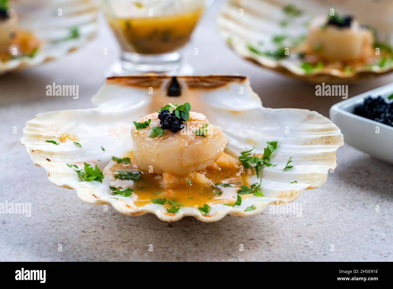 Canapes with scallops, caviar and lime and butter sauce in shells Stock Photo