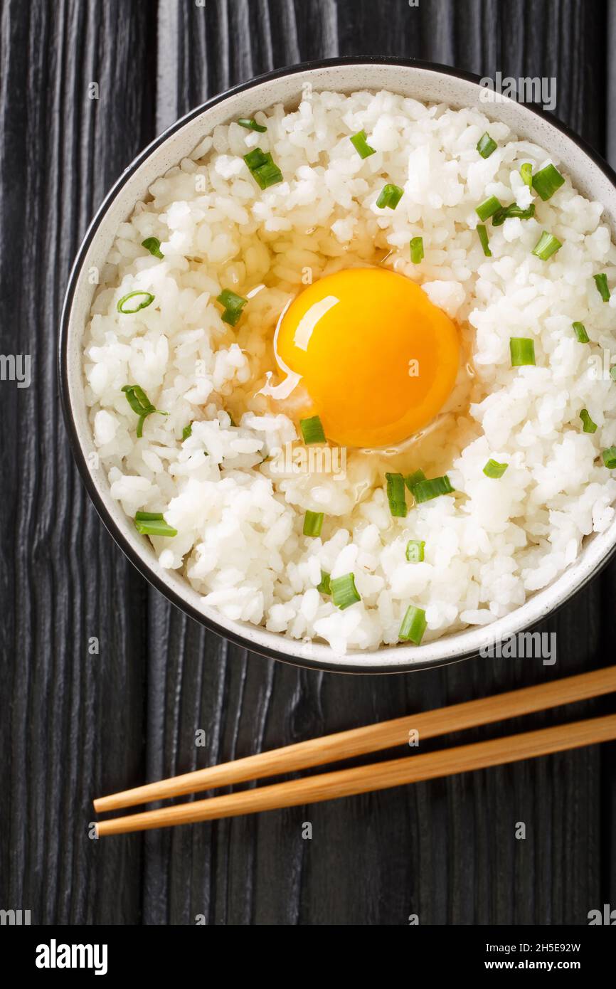 Tamago Kake Gohan Japanese Style Rice With Egg close up in the bowl on the table. Vertical top view from above Stock Photo