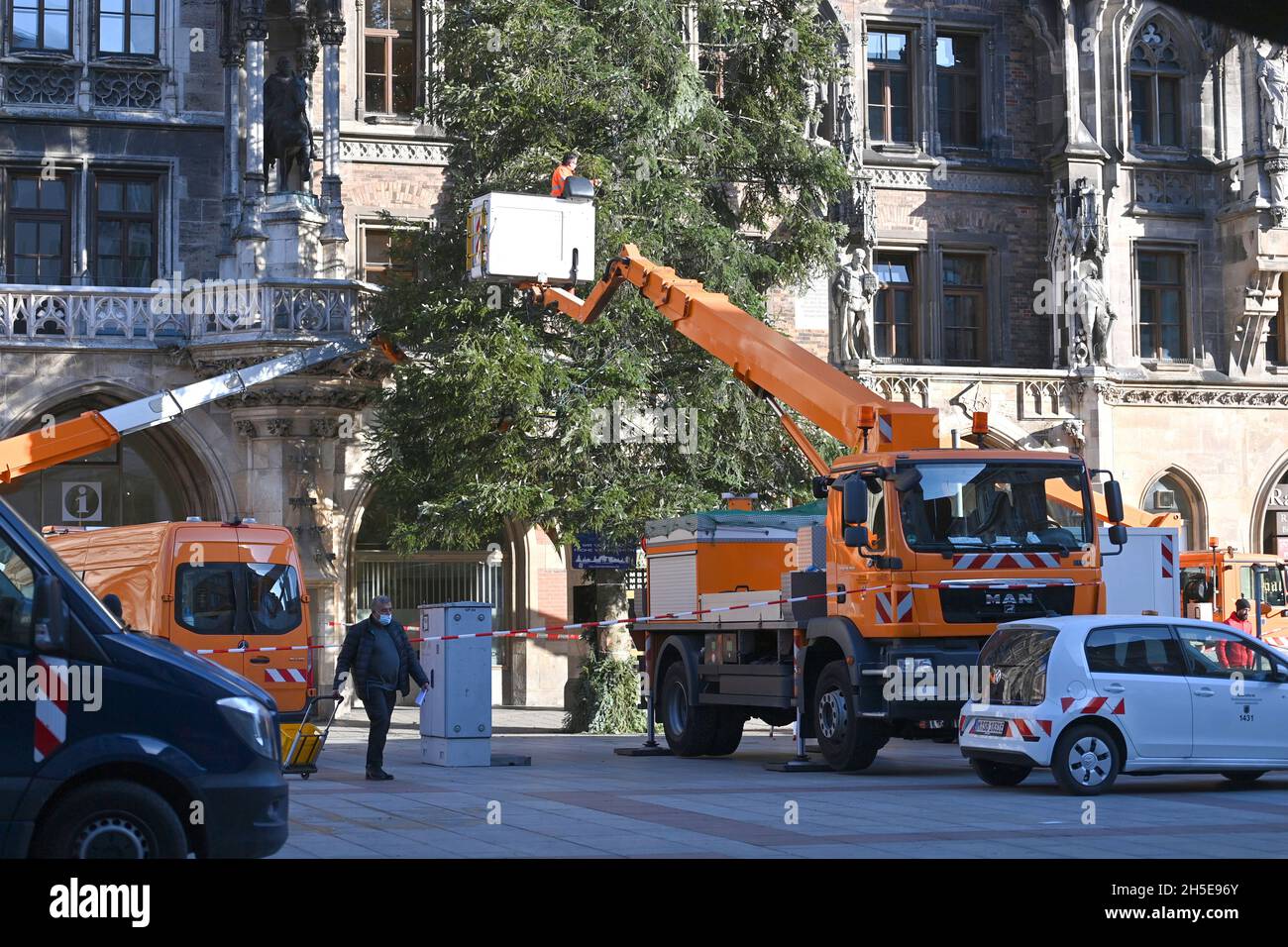 Workers on a lifting platform attach the Weihafterts lighting to the Weihaftertsbaum. Construction of the Christmas market on Marienplatz in Munich on November 9th, 2021. Stock Photo