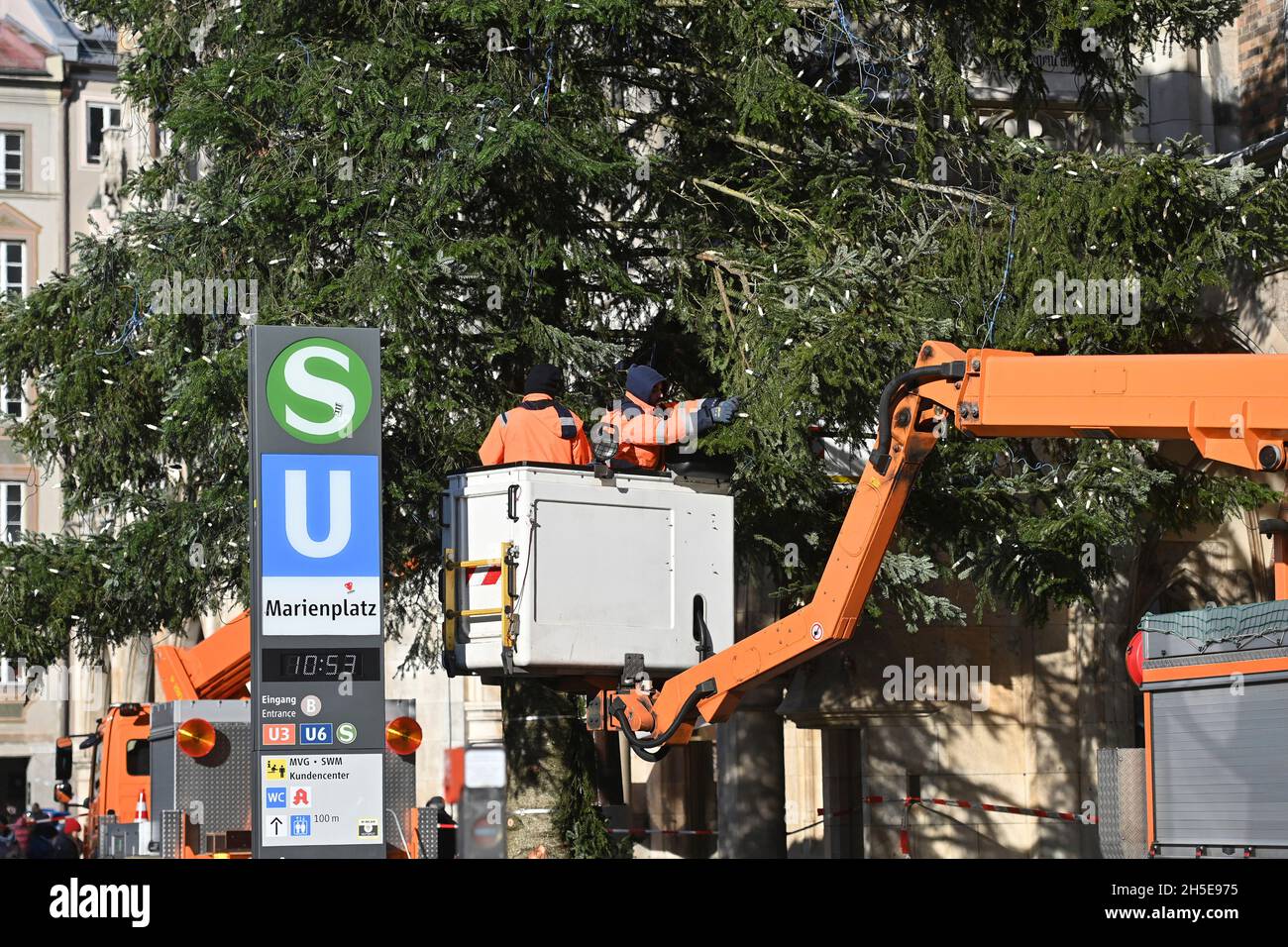 Workers on a lifting platform attach the Weihafterts lighting to the Weihaftertsbaum. Construction of the Christmas market on Marienplatz in Munich on November 9th, 2021. Stock Photo