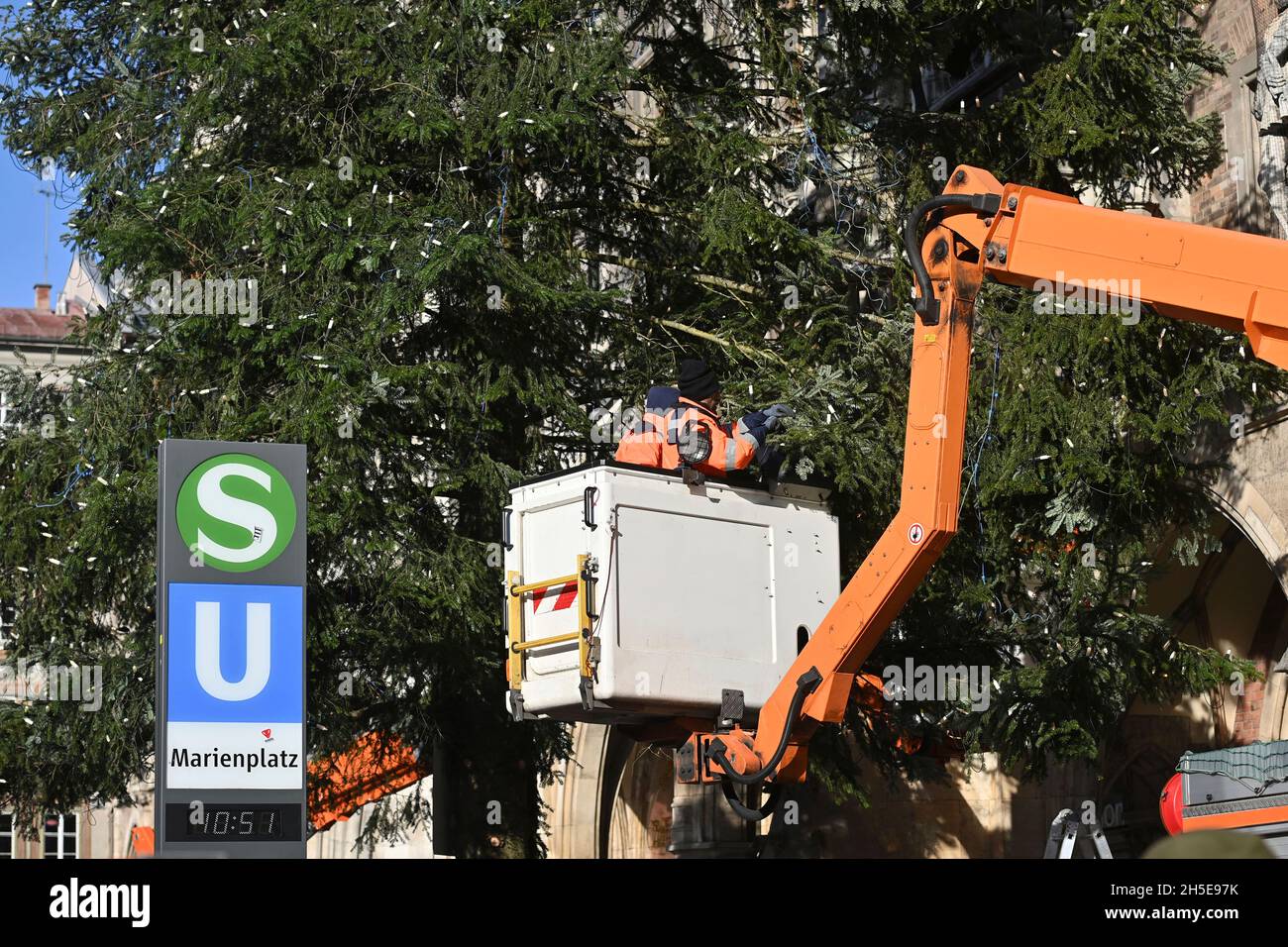 Workers on a lifting platform attach the Weihafterts lighting to the Weihaftertsbaum. Construction of the Christmas market on Marienplatz in Munich on November 9th, 2021. Stock Photo