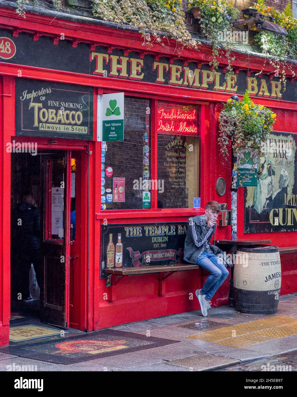 cigarette temple A young man smokes a cigarette outside Dublin's famous Temple Bar Pub Stock  Photo