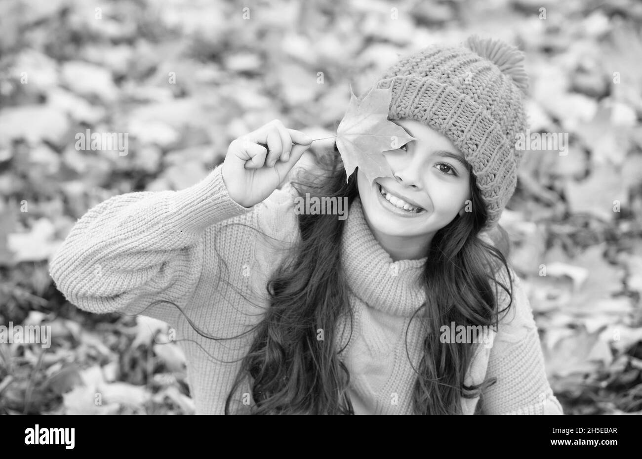 perfect autumn day of cheerful girl in knitted hat and sweater relax in fall season forest enjoying good weather, autumn fun Stock Photo