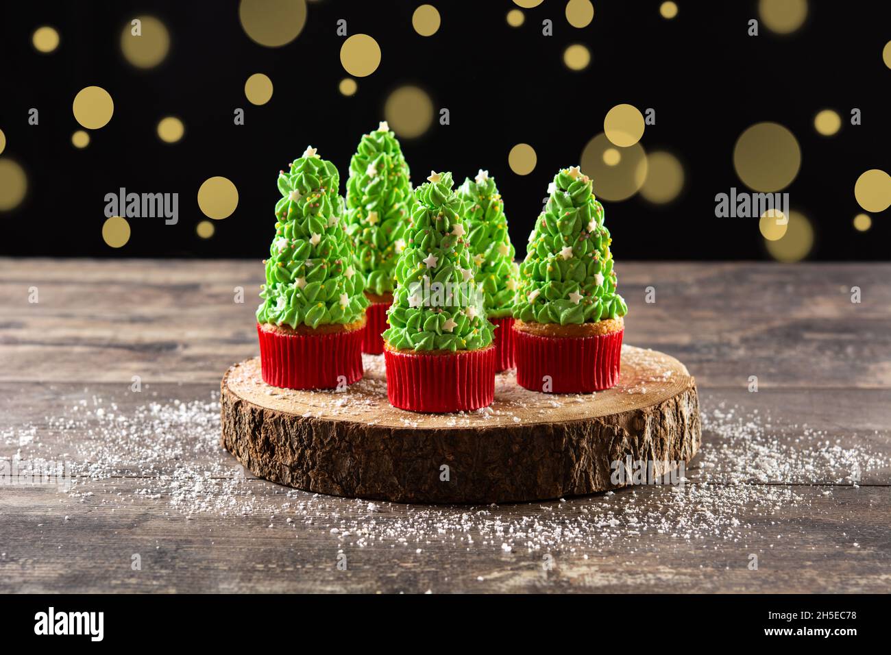 Christmas tree cupcakes on wooden table and bokeh background Stock Photo