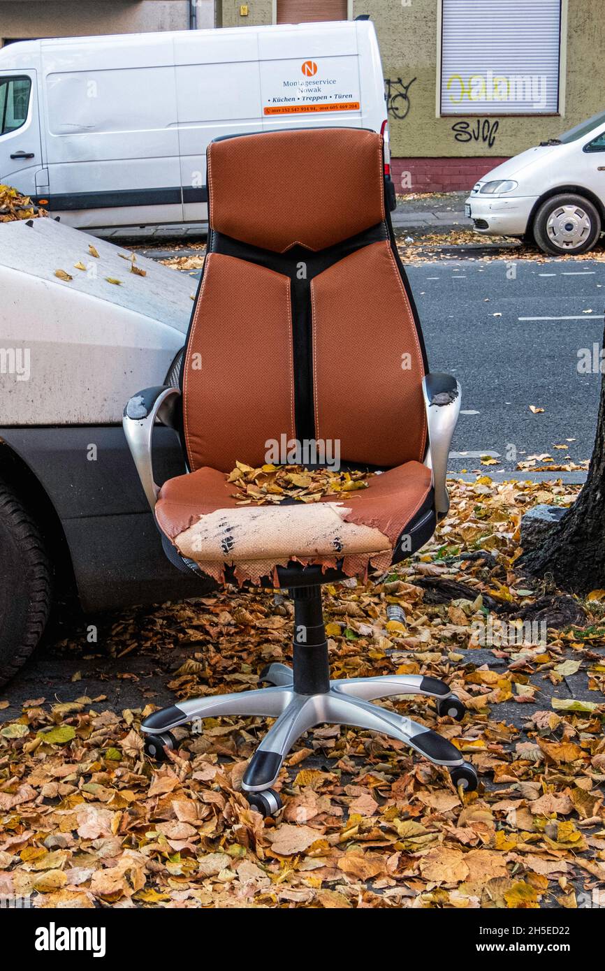 Worn & damaged office chair dumped on a sidewalk in Autumn, Mitte,Berlin Stock Photo