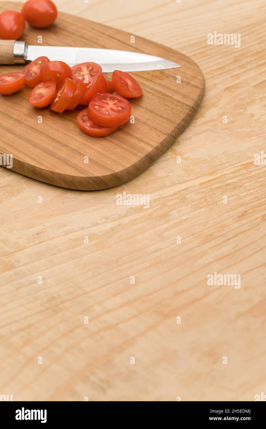 datterini tomatoes and knife on a wooden chopping board on a rustic ...