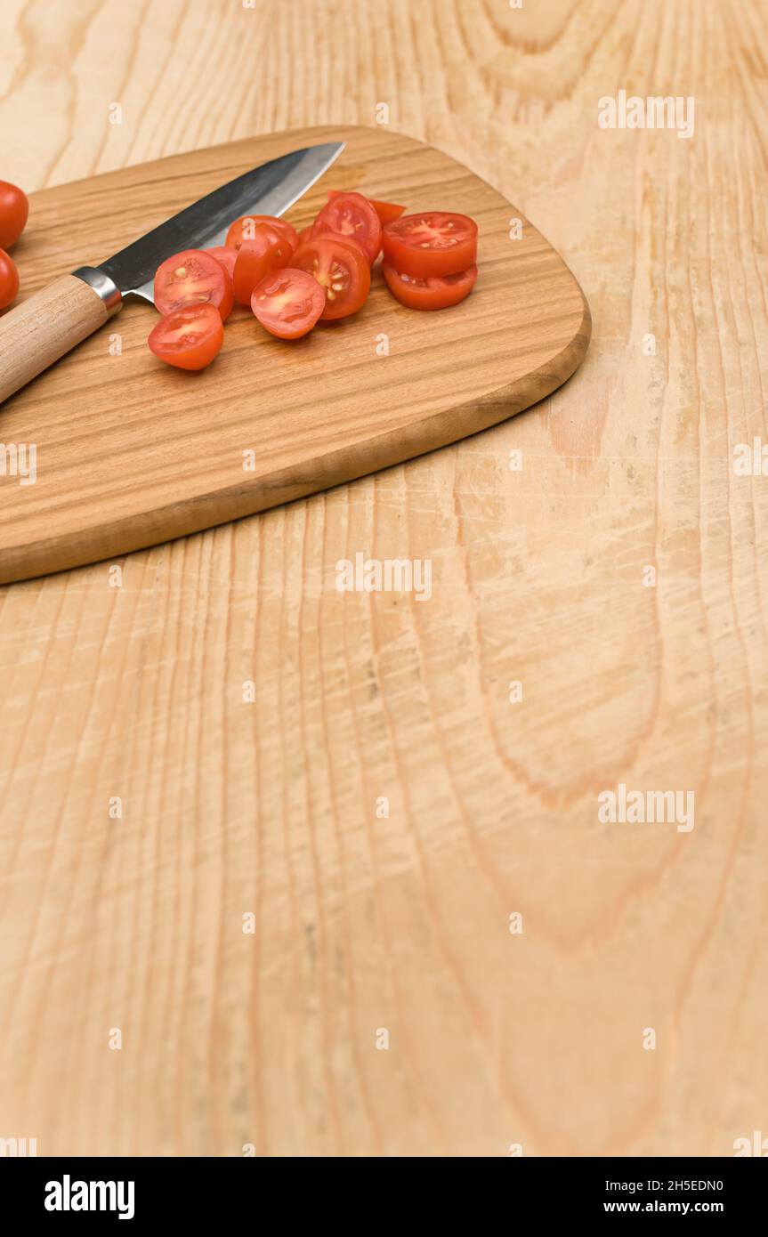datterini tomatoes and knife on a wooden chopping board on a rustic ...