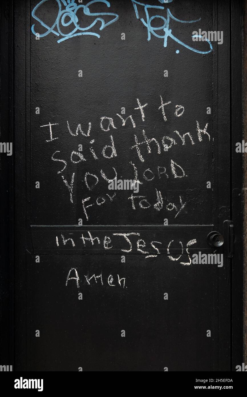A chalk written message on a door thanking Jesus for the day. On Broadway in Astoria, Queens, New York City. Stock Photo