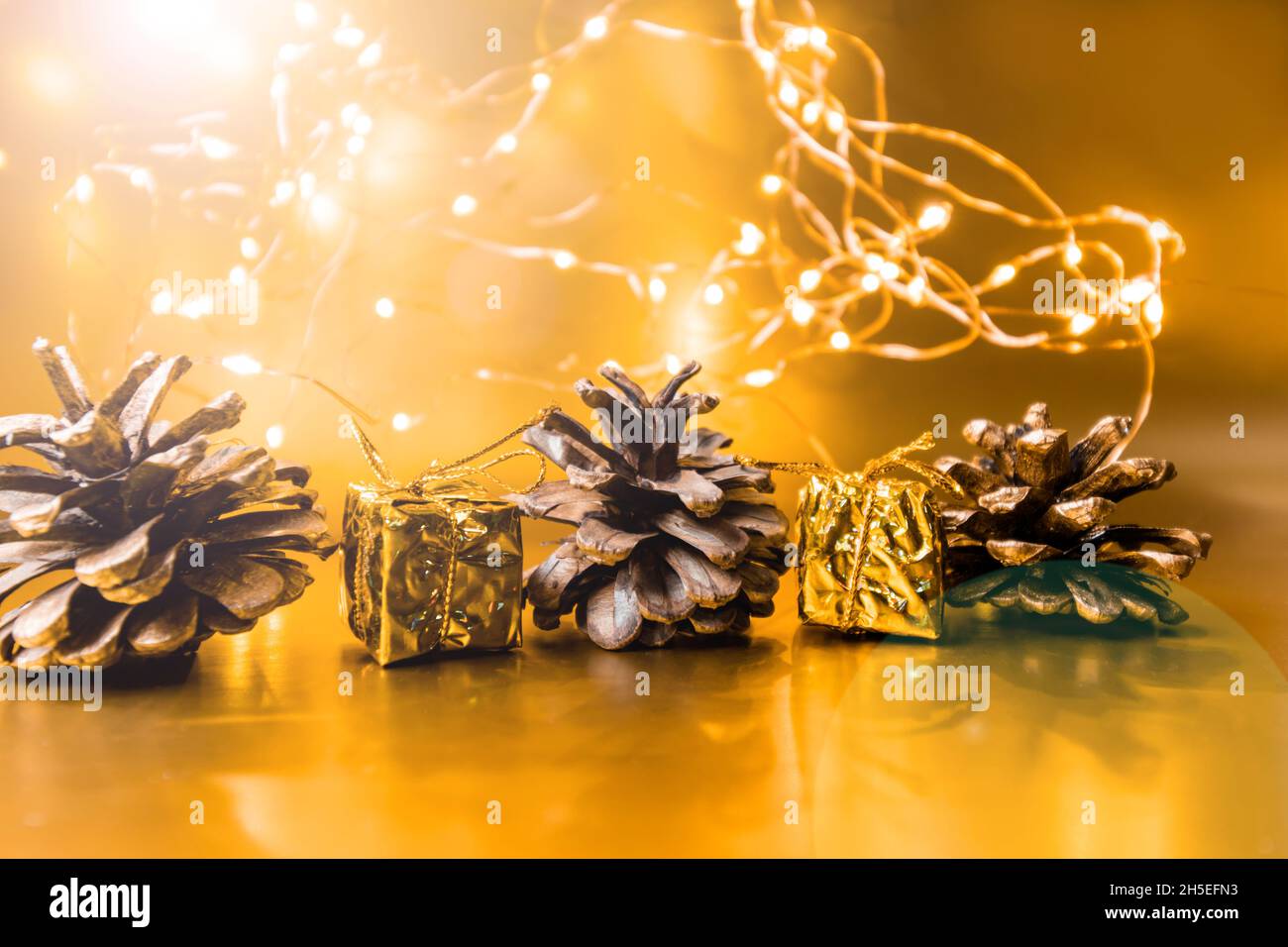 Christmas cones on a golden background. Christmas background. 2022 Stock Photo