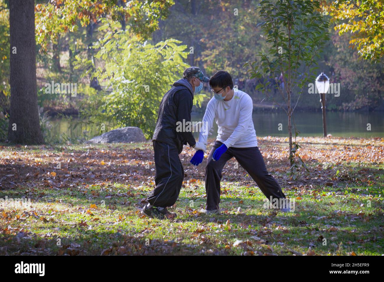 Older & younger Chinese men engage in a martialarts version of Tai Chi