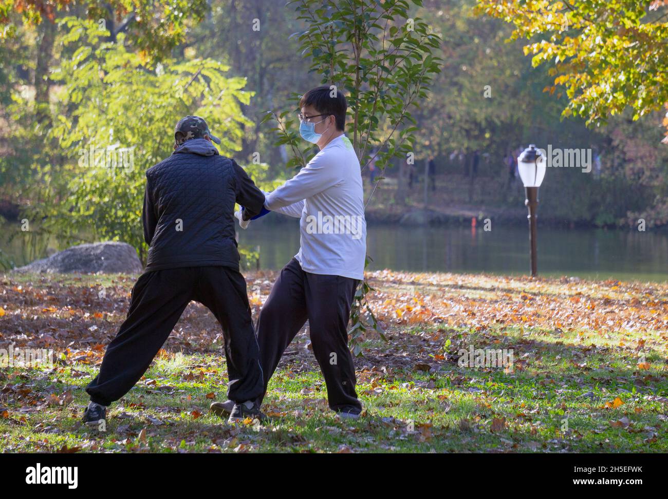 Older & younger Chinese men engage in a martialarts version of Tai Chi