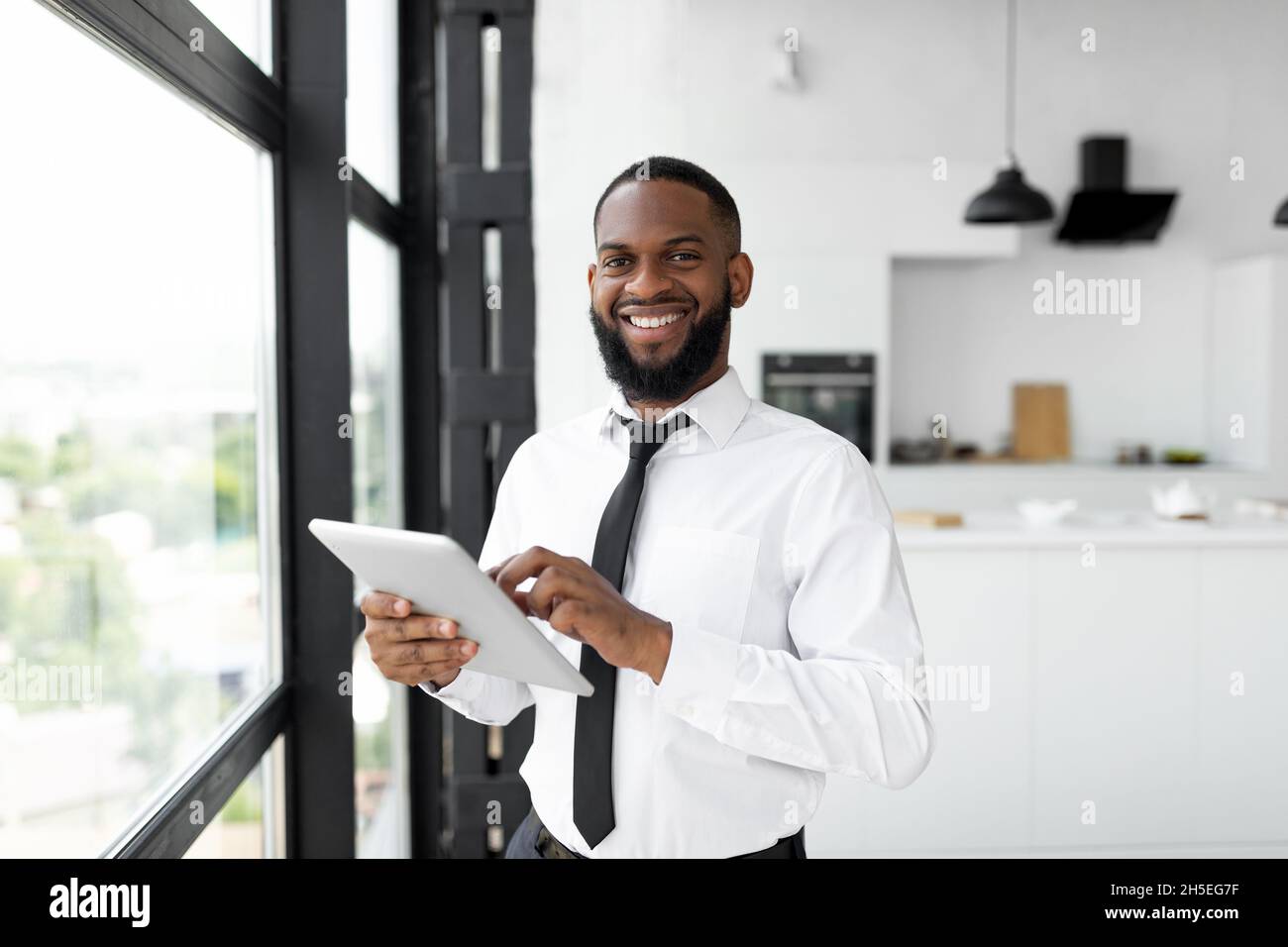 African American man using digital tablet looking at camera Stock Photo