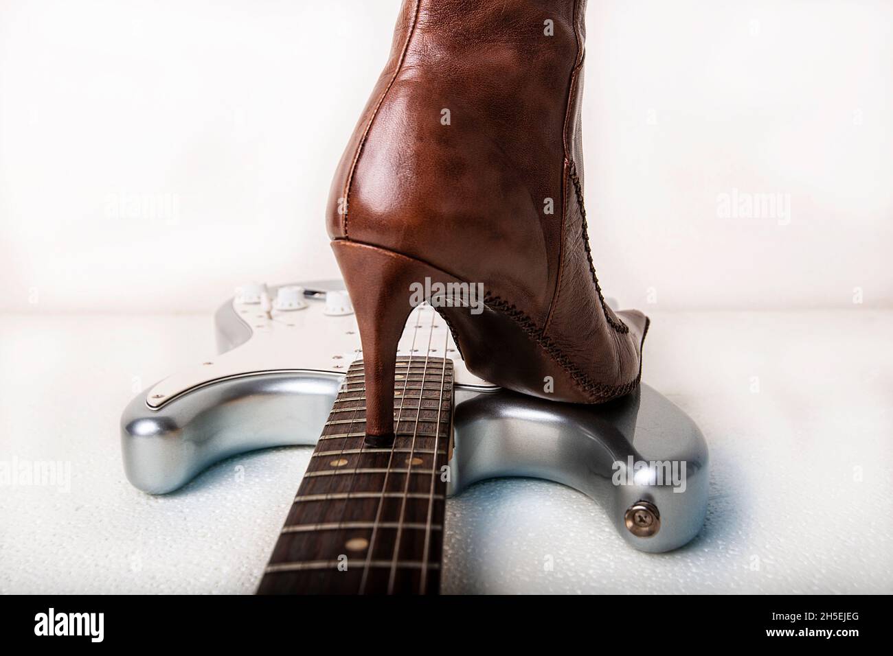 Silver electric guitar and brown women's high heels boot Stock Photo Alamy