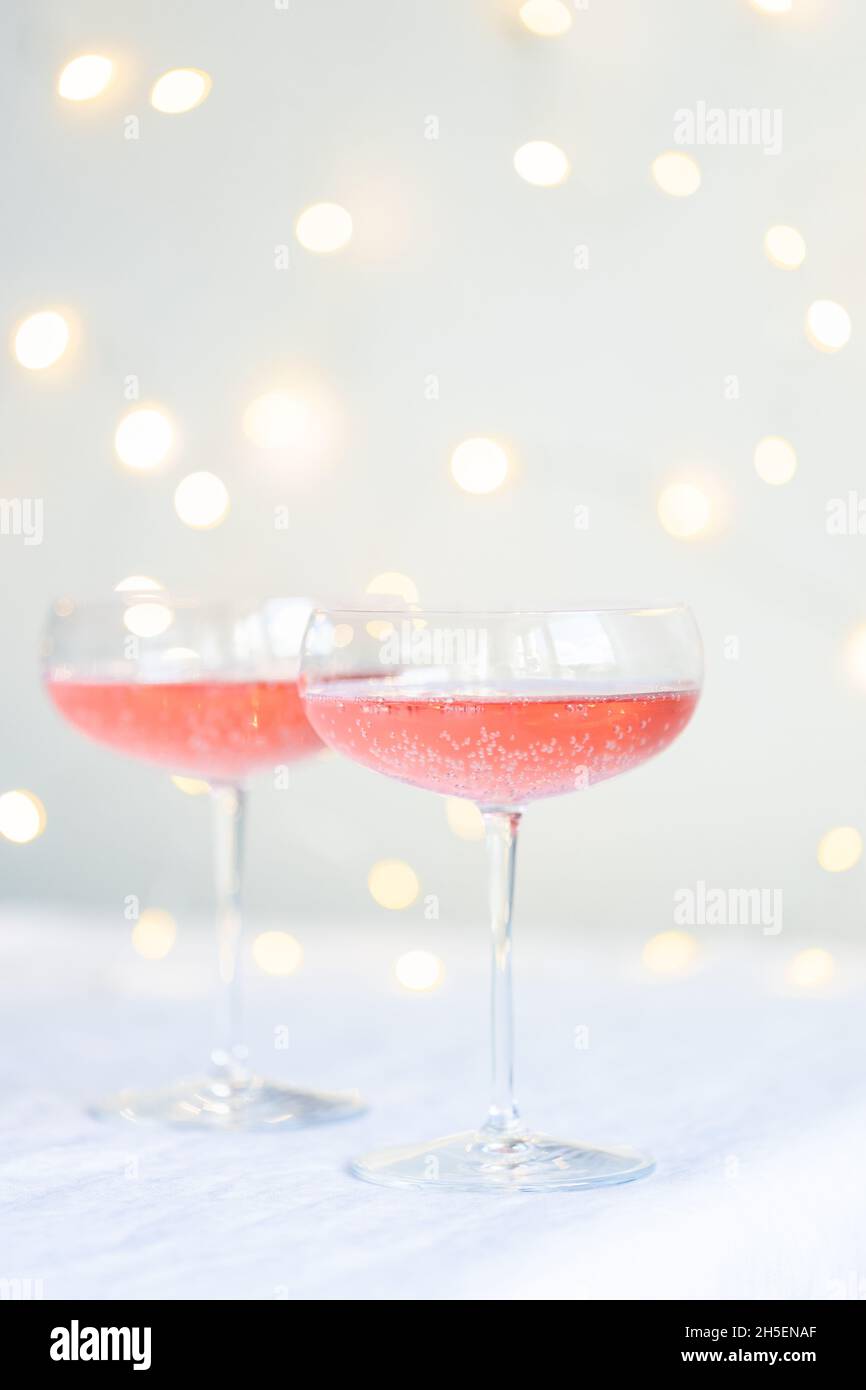 Two glasses with rose champagne against lights. Stock Photo