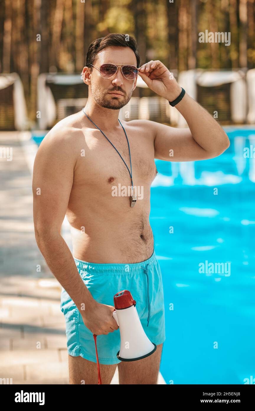Male lifeguard in sunglasses near the public swimming pool Stock Photo -  Alamy